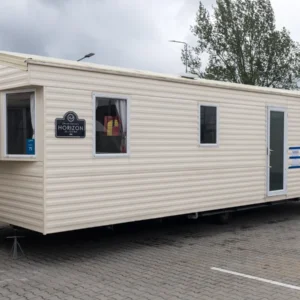 Angielski dom mobilny z białymi ramami okiennymi i białą podłogą, obok znak HORIZON